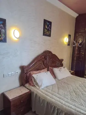 a bedroom with a wooden bed with two pillows at إقامة شاكر in Meknès