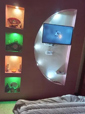 a bedroom with a mirror and a tv on a wall at إقامة شاكر in Meknès