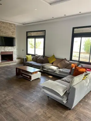 a living room with two couches and a fireplace at Domaine Farah in Meknès