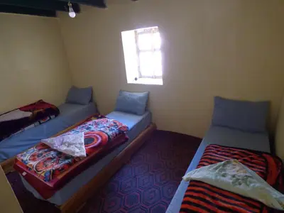 two twin beds in a room with a window at gîte taghia ahansal in Taghia