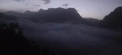 a misty valley with mountains in the background at gîte taghia ahansal in Taghia