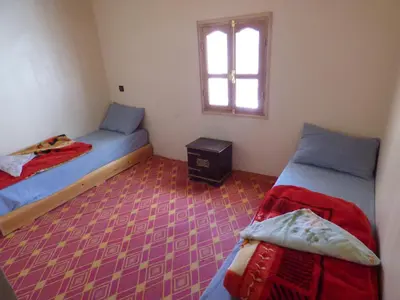 a small room with two beds and a window at gîte taghia ahansal in Taghia