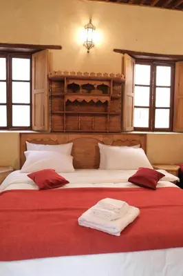 a bedroom with two beds with red and white sheets at Dar Fes Zahra in Fès