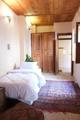 a bedroom with a large bed and a wooden ceiling at Dar Fes Zahra in Fès