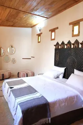 a bedroom with two beds with white sheets at Dar Fes Zahra in Fès