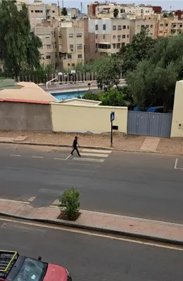 a person walking across a street in a city at Appartement Centre Ville - ATLAS 46 in Fès
