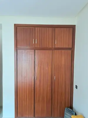 a pair of wooden closet doors in a room at Appartement Centre Ville - ATLAS 46 in Fès