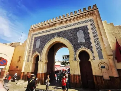 a building with an arch with people standing around it at Appartement Centre Ville - ATLAS 46 in Fès