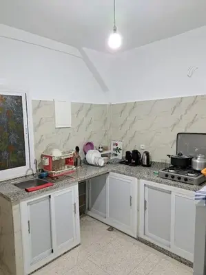 a kitchen with white cabinets and a counter top at Appartement Atlas City Center 2 in Fès