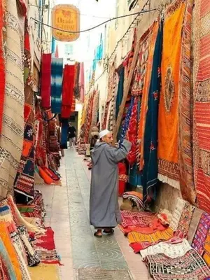 a man is looking at a shop in a market at Appartement Atlas City Center 2 in Fès