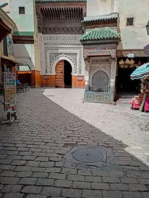 a building with an arch in the middle of a street at Appartement Atlas City Center 2 in Fès