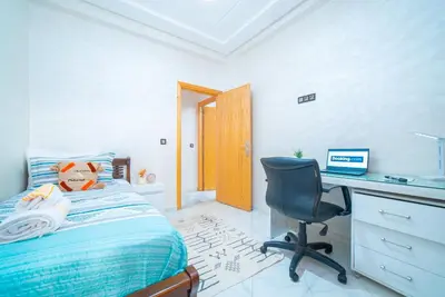 a bedroom with a bed and a desk and a chair at Familiale, raffinement et calme, entourée d'une vue sur le jardin - À proximité de l'aéroport et de Marjane in Fès