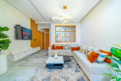 a living room with a couch and a table at Familiale, raffinement et calme, entourée d'une vue sur le jardin - À proximité de l'aéroport et de Marjane in Fès