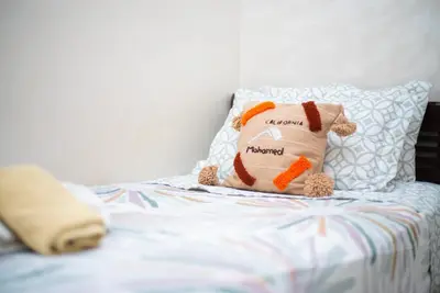 a stuffed teddy bear sitting on a bed at Familiale, raffinement et calme, entourée d'une vue sur le jardin - À proximité de l'aéroport et de Marjane in Fès