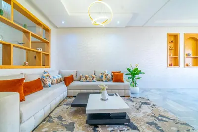 a living room with a couch and a table at Familiale, raffinement et calme, entourée d'une vue sur le jardin - À proximité de l'aéroport et de Marjane in Fès