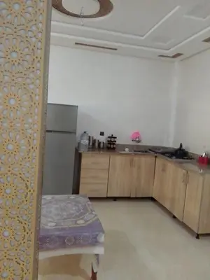 a kitchen with a refrigerator and a table in a room at Tifelt in Tiflet