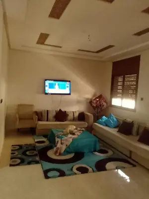 a living room with a couch and a table on a rug at Tifelt in Tiflet