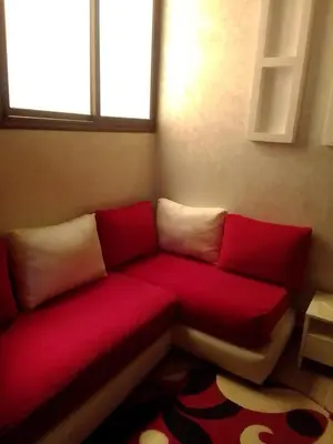 a red couch with white pillows in a room at Tifelt in Tiflet