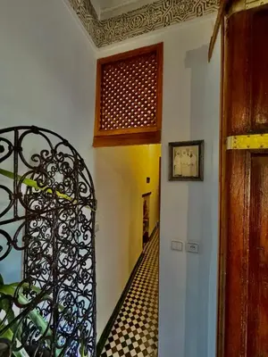 a hallway with a wrought iron door and a tile floor at Appartement khmissa in Fès al Bali
