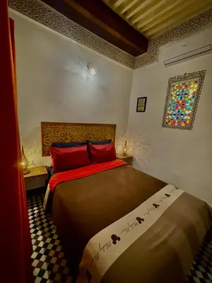 a bedroom with a bed and a stained glass window at Appartement khmissa in Fès al Bali
