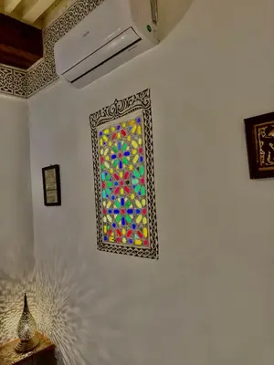 a colorful window on a white wall in a room at Appartement khmissa in Fès al Bali