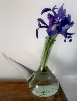 a glass vase with purple flowers in it at Appartement khmissa in Fès al Bali