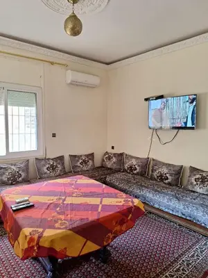 a living room with a couch and a tv at Fes City Center Comfy Apartment in Fès