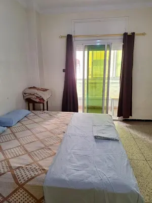 a bedroom with a bed and a sliding glass door at Fes City Center Comfy Apartment in Fès