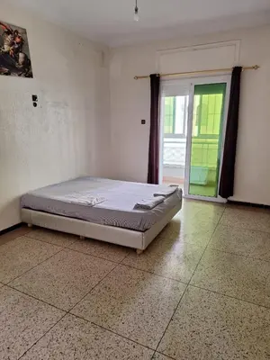 a bed sitting in a room with a window at Fes City Center Comfy Apartment in Fès