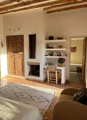 a living room with a couch and a fireplace at Dar Tasmayoun in Aït Ourir