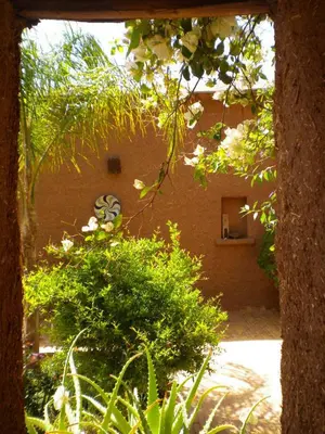 a view of a building through a window of a garden at Dar Tasmayoun in Aït Ourir