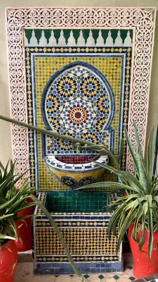 a colorful tile wall with plants in front of it at Dar Tagore in Fès