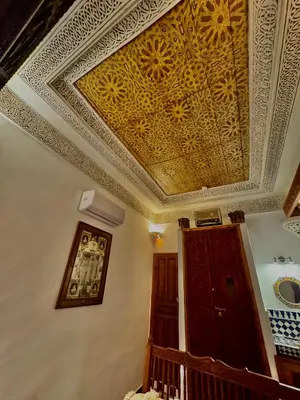 a room with a ceiling with a painting on it at Dar Tagore in Fès