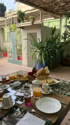 a table with plates of food and orange juice at Dar Tagore in Fès