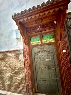 a wooden door with stained glass on a building at Riad Phœnix in Fès al Bali