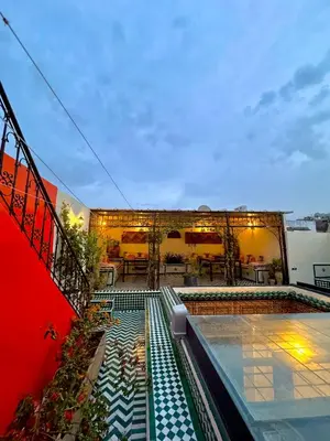 a building with a swimming pool and a patio at Riad Phœnix in Fès al Bali
