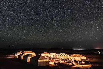 a row of tents under a starry night sky at Aaladdin luxury camp in Merzouga