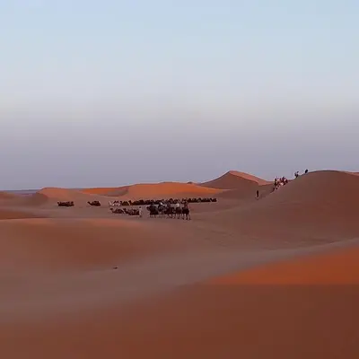a group of people riding horses in the desert at Aaladdin luxury camp in Merzouga