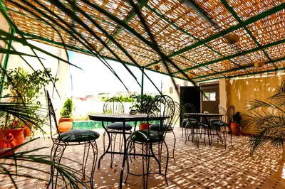 a patio with tables and chairs under a pergola at Dar Ibn Majdoub Lala aicha & Alia in Fès