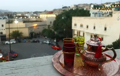 a tray with three glasses and a tea pot on a table at Dar Ibn Majdoub Lala aicha & Alia in Fès