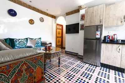 a living room with a couch and a refrigerator at Dar Ibn Majdoub Lala aicha & Alia in Fès