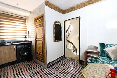 a room with a bathroom with a washing machine and a door at Dar Ibn Majdoub Lala aicha & Alia in Fès