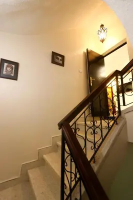 a stairway with a wrought iron railing and a door at Dar Ibn Majdoub Lala aicha & Alia in Fès