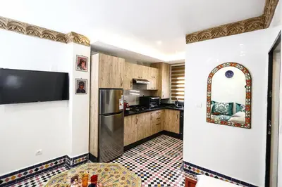 a kitchen with a refrigerator and a counter at Dar Ibn Majdoub Prive Entier in Fès