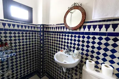 a blue and white bathroom with a sink and a mirror at Dar Ibn Majdoub Prive Entier in Fès