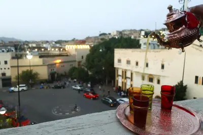 a tray with four cups on a ledge with a view of a street at Dar Ibn Majdoub Prive Entier in Fès
