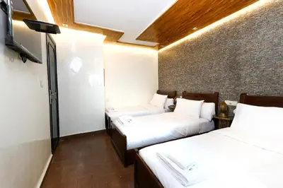 two beds in a room with a brick wall at Dar Ibn Majdoub Prive Entier in Fès