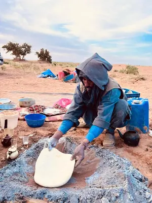 a person in the desert playing in the dirt at Oasis source de vie in Mhamid