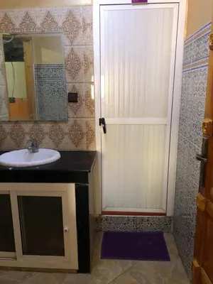 a bathroom with a sink and a white door at Mahmoud moulay Yacoub 1 in Moulay Yacoub