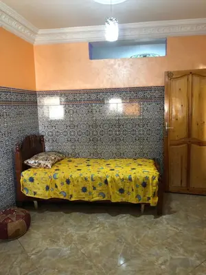a bedroom with a bed with a yellow blanket at Mahmoud moulay Yacoub 1 in Moulay Yacoub